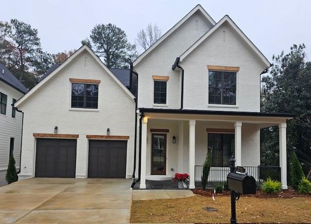 View of front of home featuring a garage and a porch