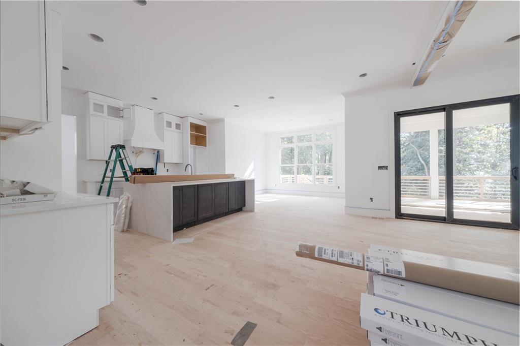 Kitchen featuring a kitchen island, light wood-type flooring, white cabinetry, and sink