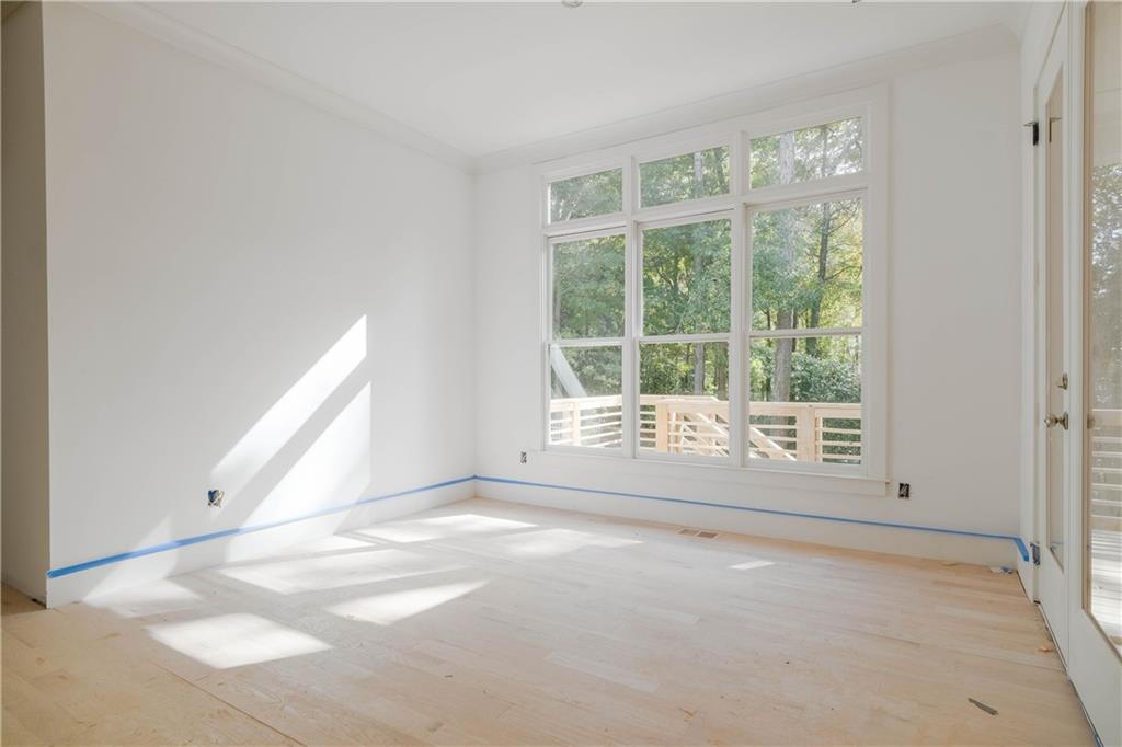 Empty room featuring light wood-type flooring and crown molding