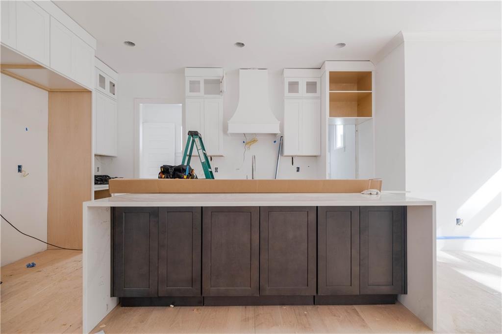 Kitchen featuring white cabinets and light hardwood / wood-style flooring