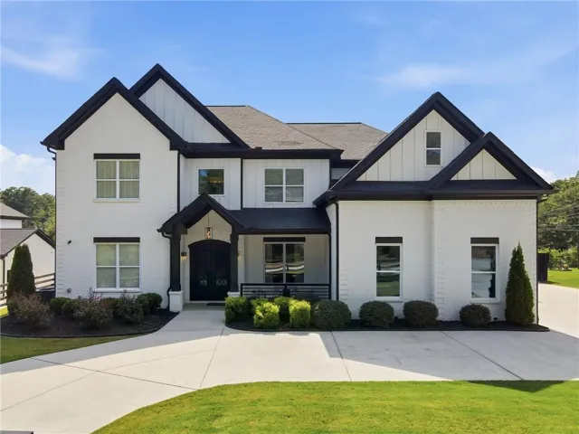 Contemporary two-story residence featuring a striking black and white exterior with steeply pitched rooflines and decorative gables
