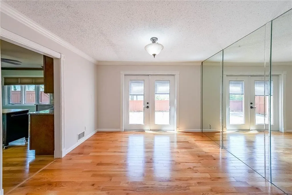 Spare room with french doors, light hardwood / wood-style floors, and ornamental molding