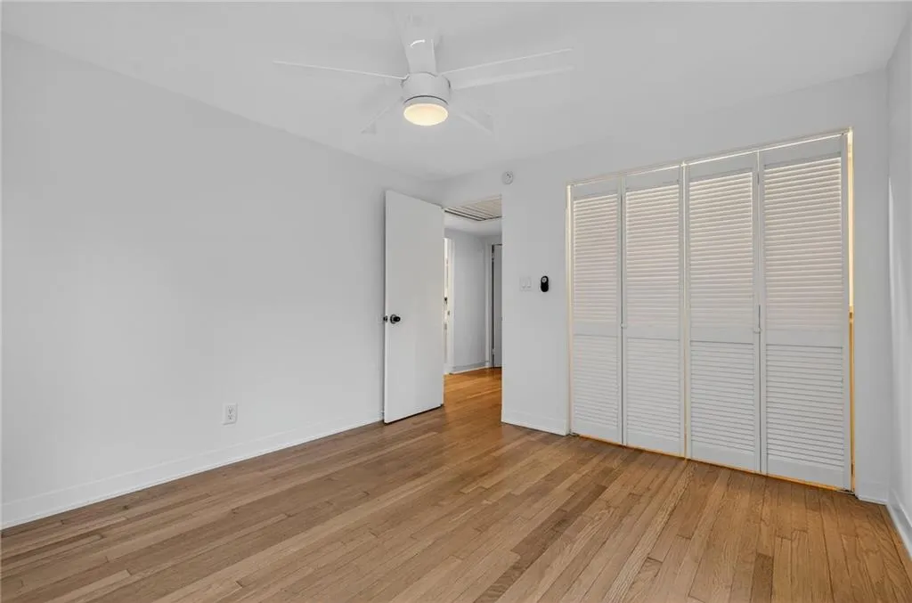 Unfurnished bedroom featuring light wood-style floors, ceiling fan, and a closet