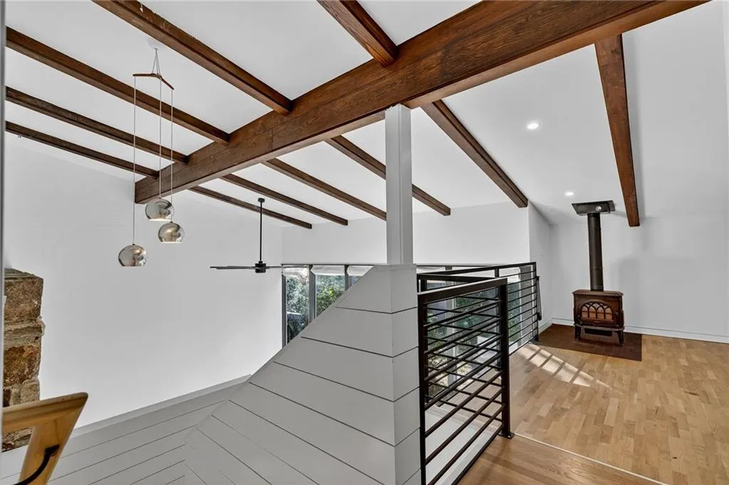 Stairs featuring a wood stove, wood finished floors, recessed lighting, and a ceiling fan