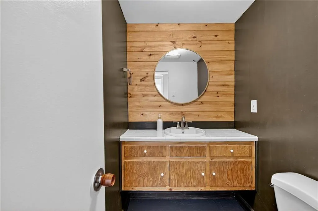 Half bathroom with wooden walls and vanity