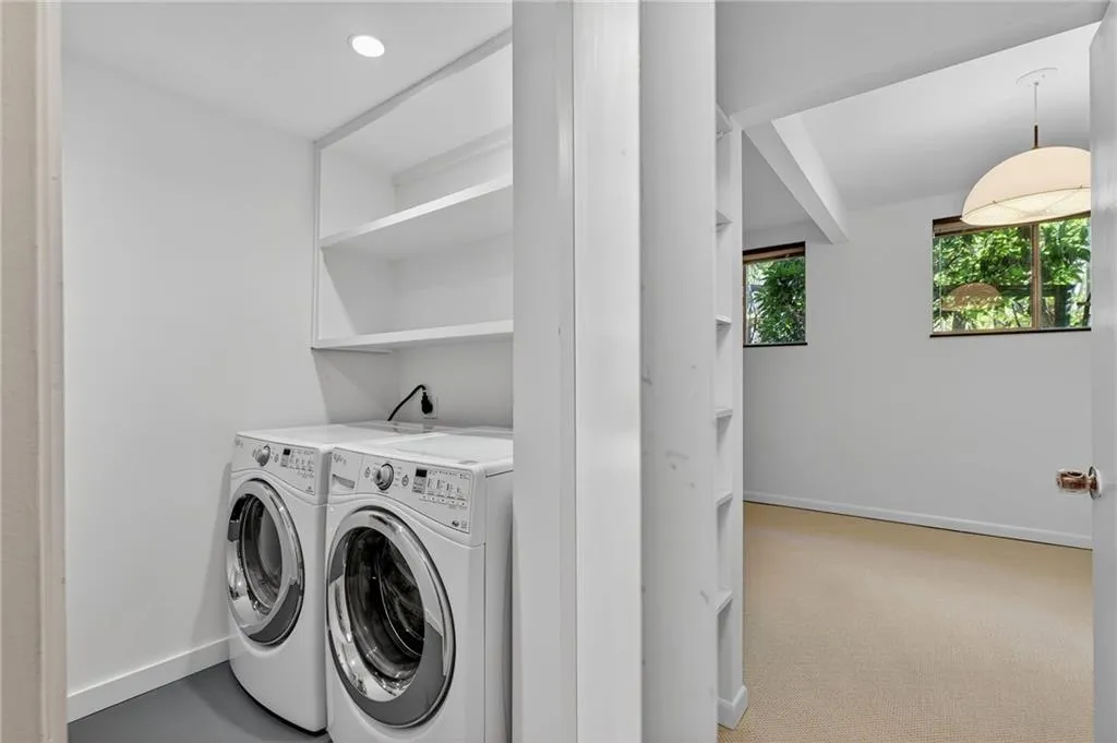 Washroom featuring washing machine and dryer and light colored carpet