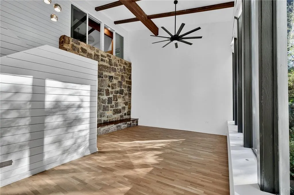 Unfurnished dining area featuring beam ceiling, light wood-type flooring, and coffered ceiling