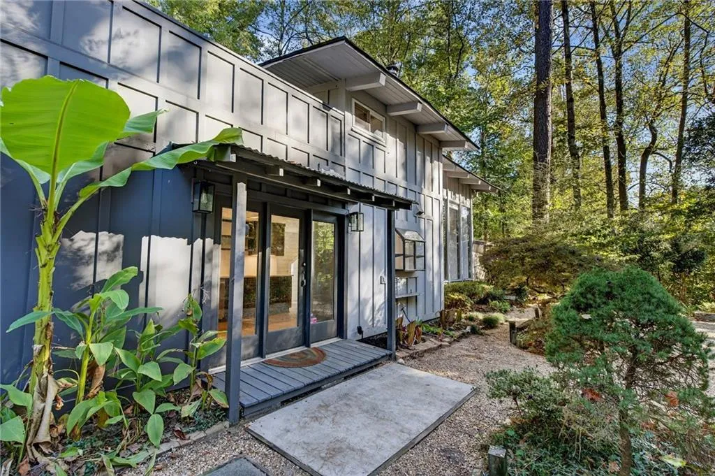 View of exterior entry with board and batten siding and a patio area