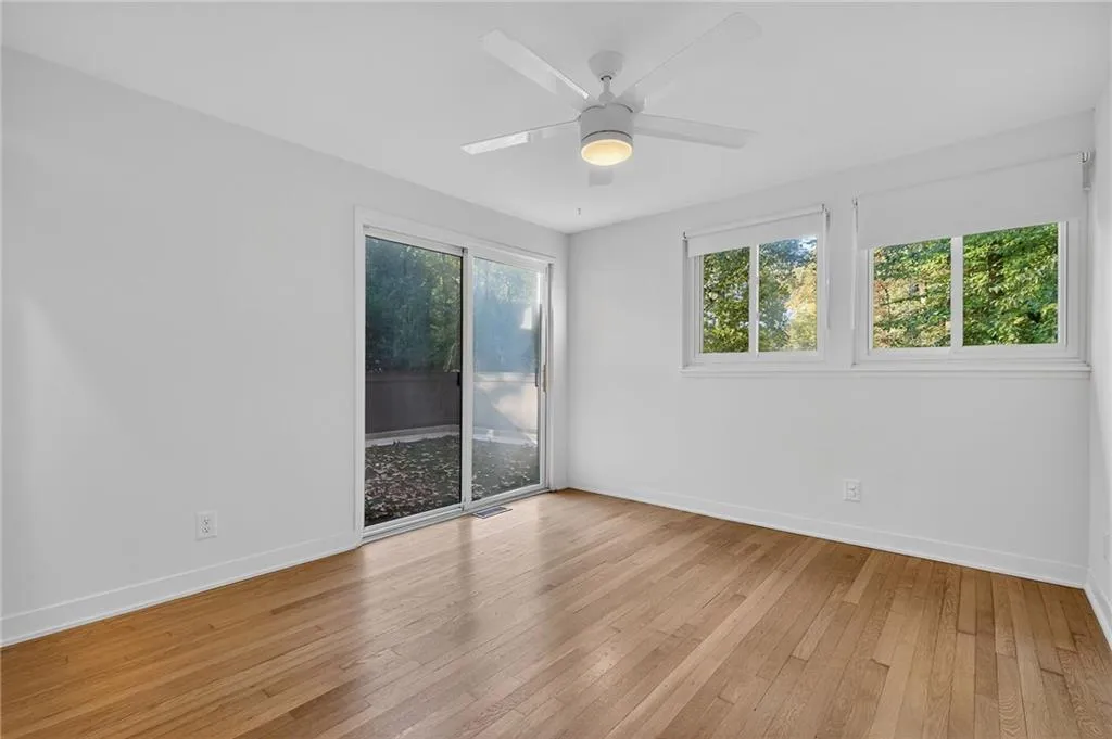 Spare room with plenty of natural light, light wood-style floors, and ceiling fan