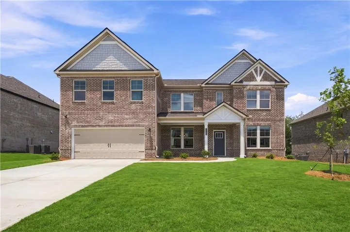 Two-story brick exterior featuring a two-car garage, covered entry with columns, and gable accents with shingle siding