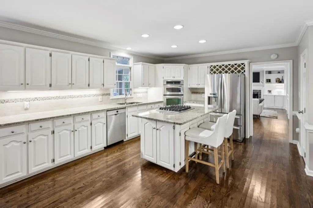 The Chef's Kitchen impresses with a Large Granite Island, White Cabinets, Stainless Steel Appliances, a Walk-In Pantry, and a cozy Breakfast Nook wrapped in windows with direct access to the Private Back Deck ideal for Al Fresco Dining.