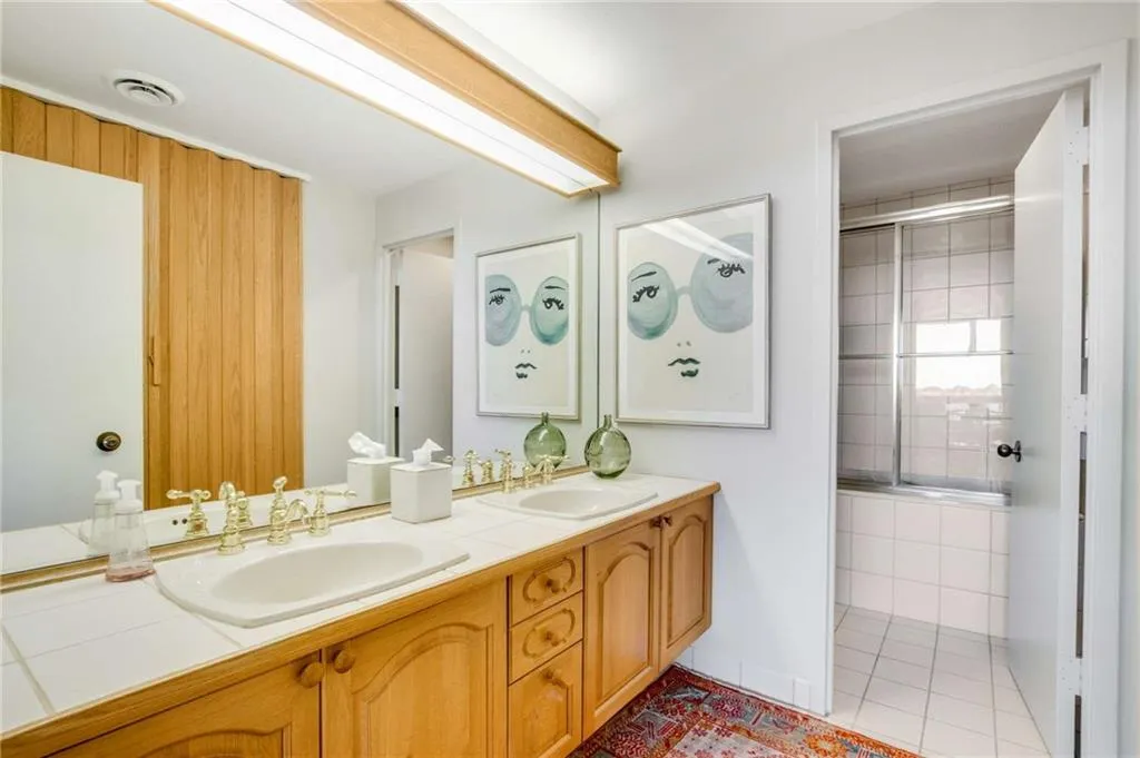 Full bath featuring double vanity, a shower stall, and light tile patterned floors