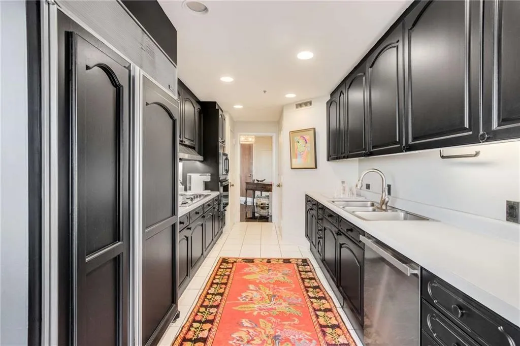 Kitchen with dark cabinetry, stainless steel appliances, recessed lighting, and light tile patterned floors