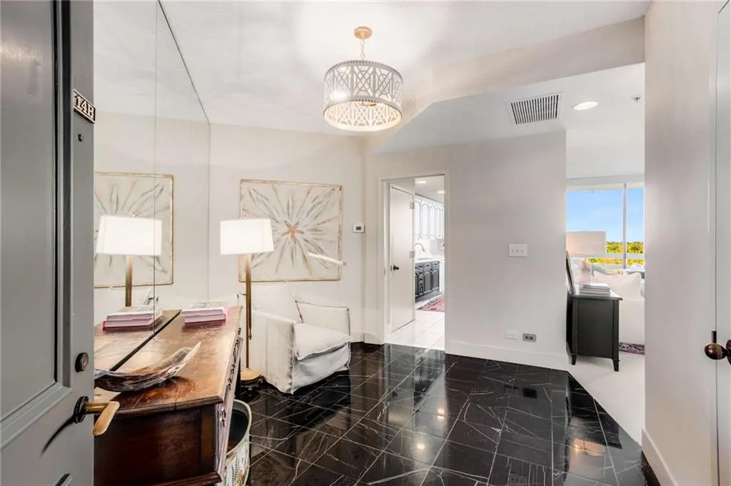 Foyer featuring baseboards and a chandelier