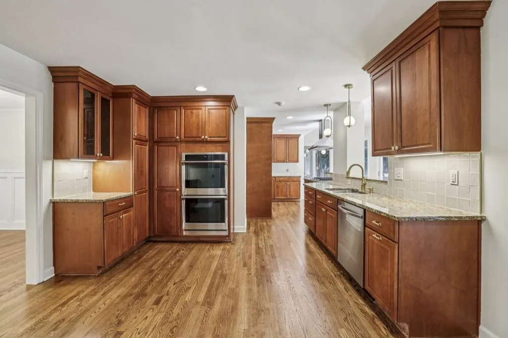 Chef's Kitchen With Granite Counters, Dark Cabinetry, A Breakfast Bar, & Breakfast Room
