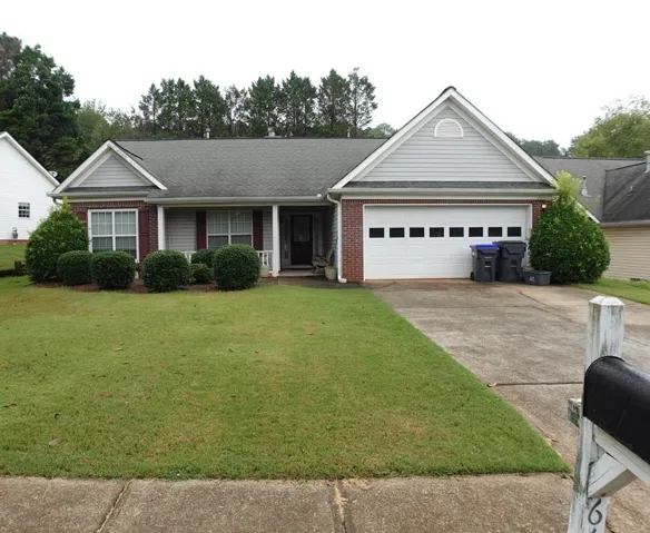 Single-story residence featuring a brick facade with light gray siding accents and a covered front porch