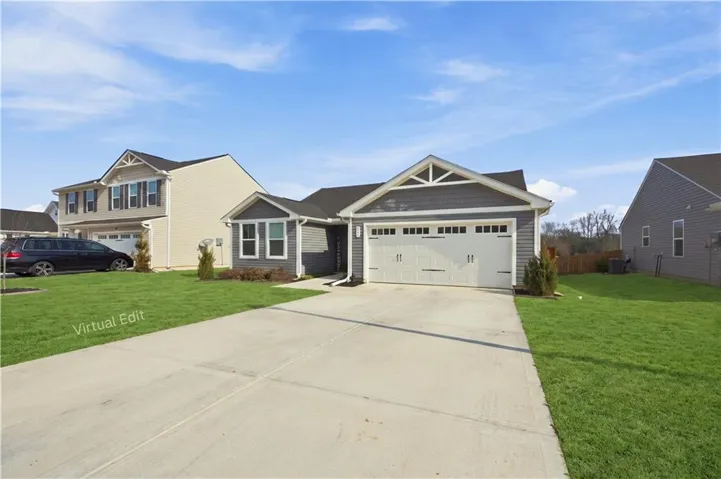 Two-car attached garage with white panel doors, gray horizontal siding, and a gabled roofline