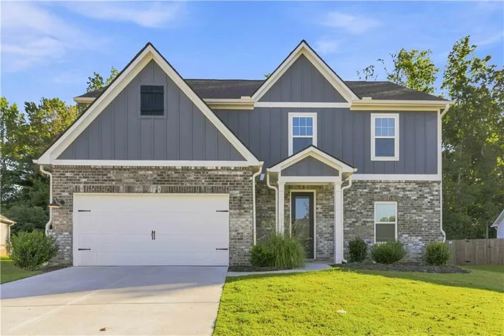Two-story exterior with brick and siding facade, covered front entry, attached garage, and a concrete driveway