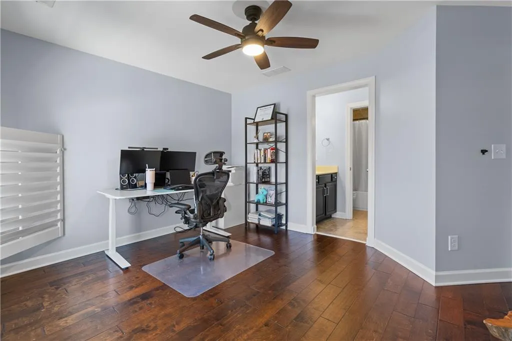 Home office with visible vents, baseboards, ceiling fan, and wood-type flooring