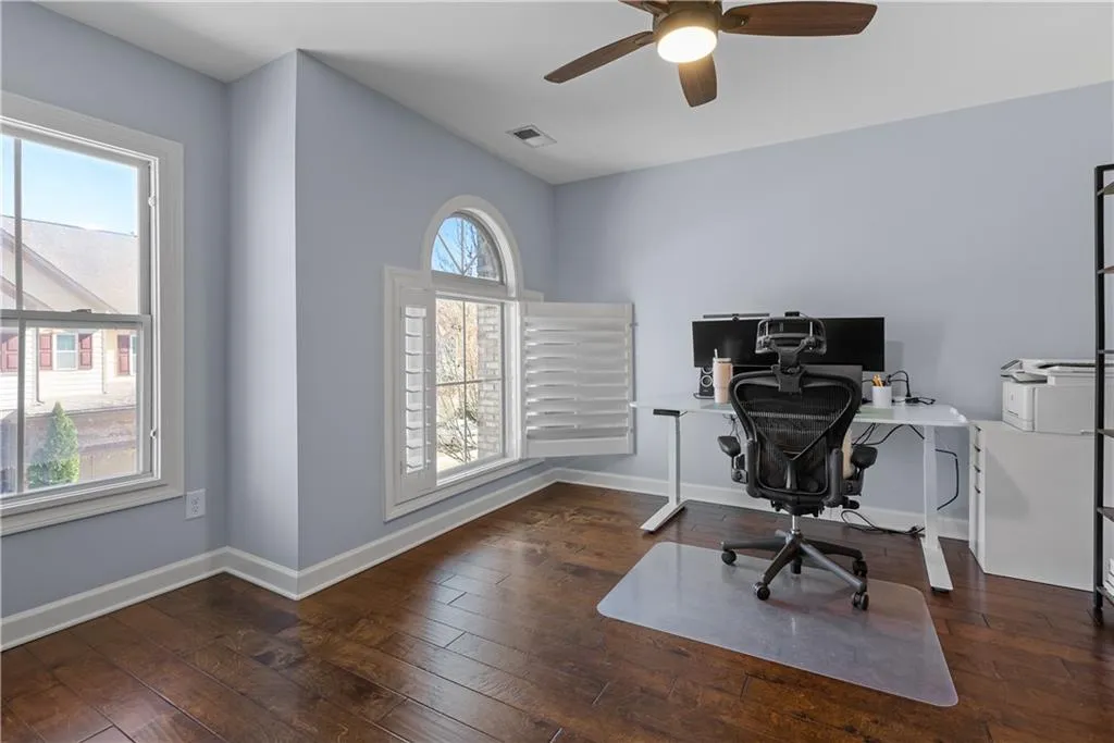 Office area with baseboards, plenty of natural light, and hardwood / wood-style floors