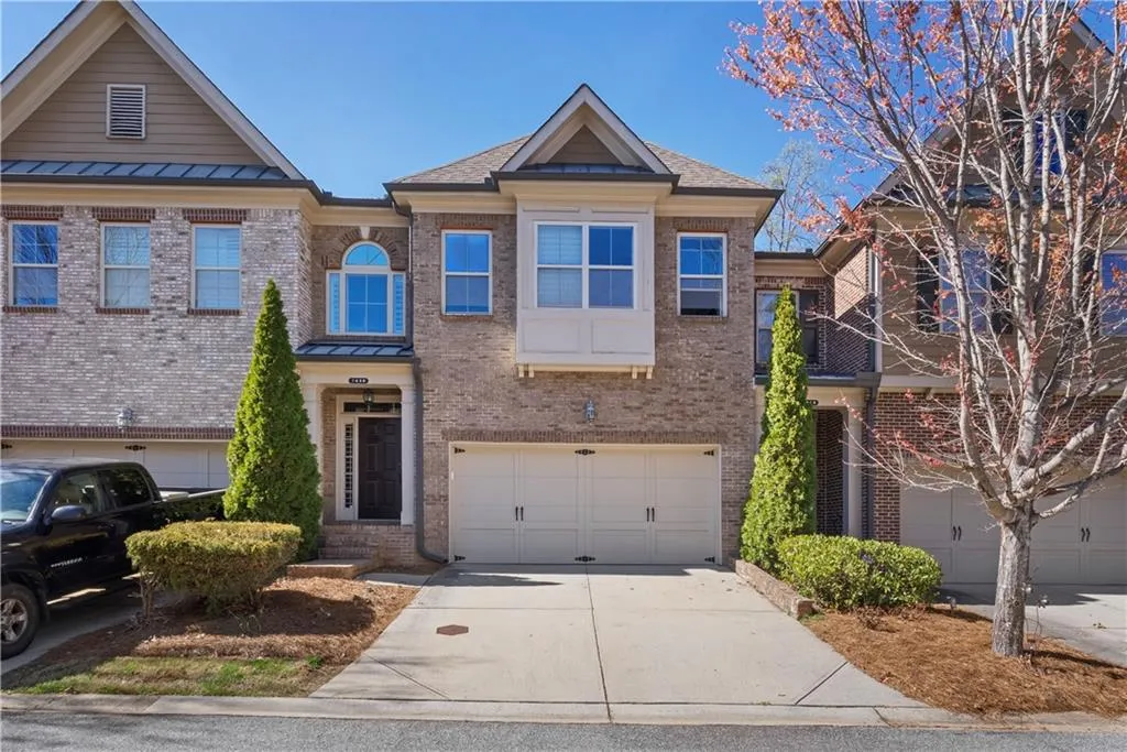 View of front of home featuring brick front and 2-car garage