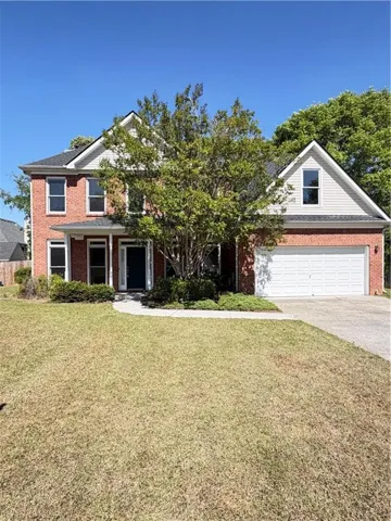 Brick-front exterior with white siding accents and a covered front entry