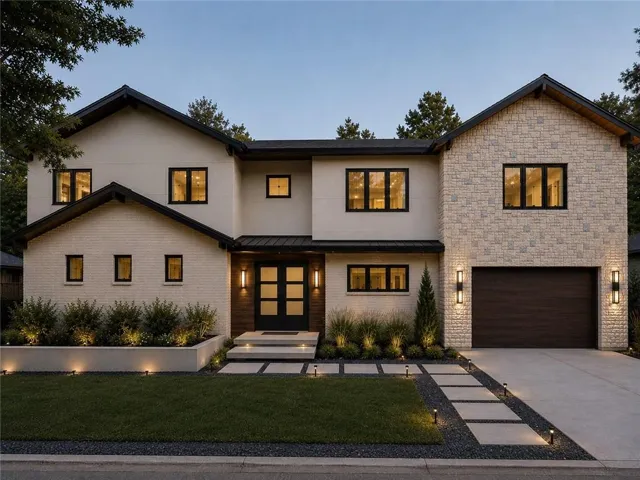 Two-story property featuring a stone and stucco facade, a dark wood-finish garage door, and a concrete driveway