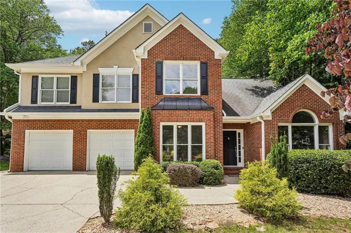 Brick and stucco exterior with multiple gables and a covered entry