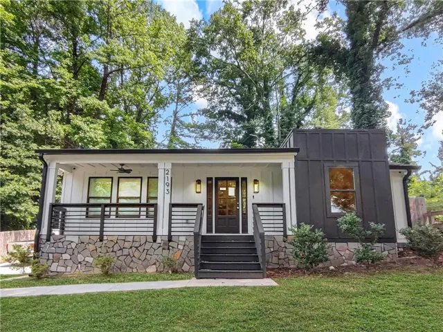 Modern farmhouse exterior featuring black board-and-batten siding and white horizontal siding