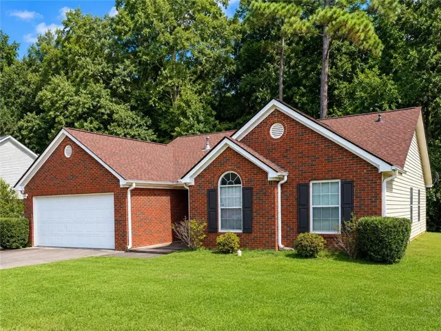 Brick facade with white siding accents and a warm-toned shingle roof