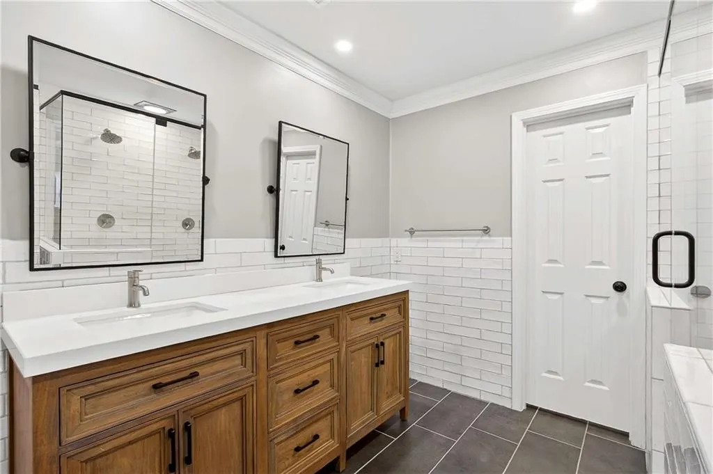 Gorgeous, renovated ensuite bathroom with dual vanity and separate toilet room with built-ins for additional storage