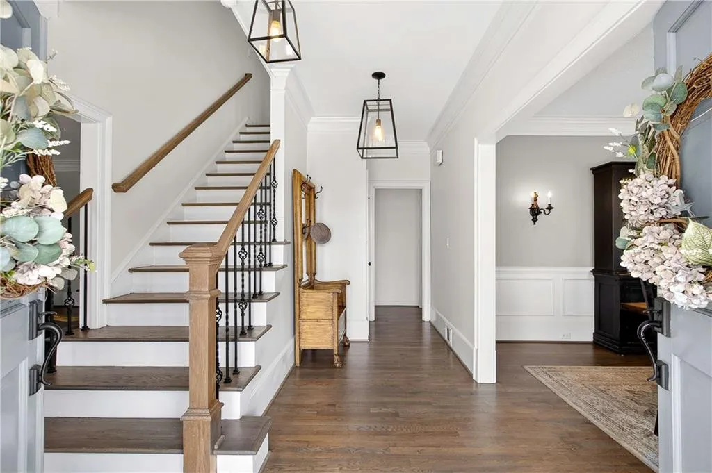Large dedicated foyer to greet guests as they arrive - note the updated staircase, refinished hardwood floors and updated lighting.
