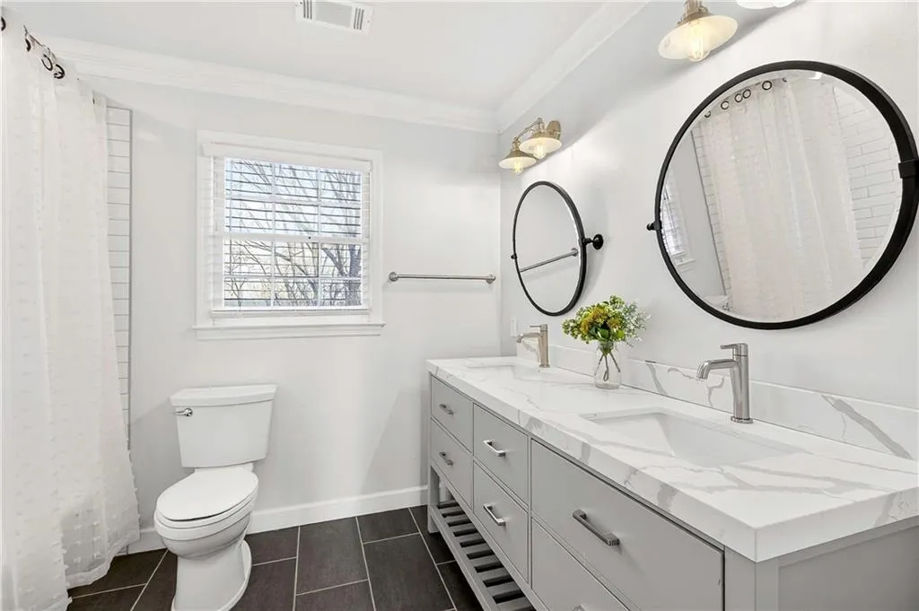 Shared upstairs guest bathroom that's been totally renovated and features a dual vanity and tub/shower combo.