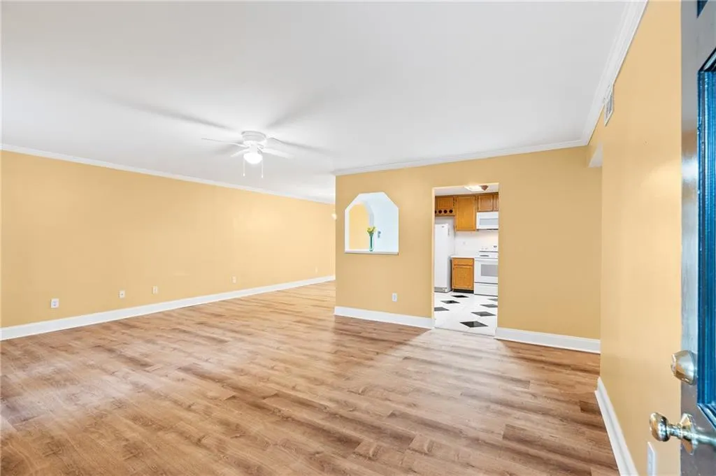 Spare room featuring light hardwood / wood-style floors, ceiling fan, and crown molding