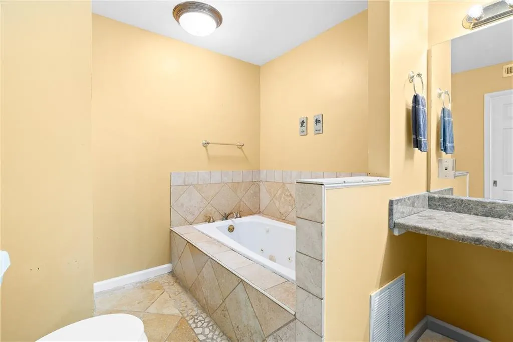 Bathroom featuring vanity and tiled bath
