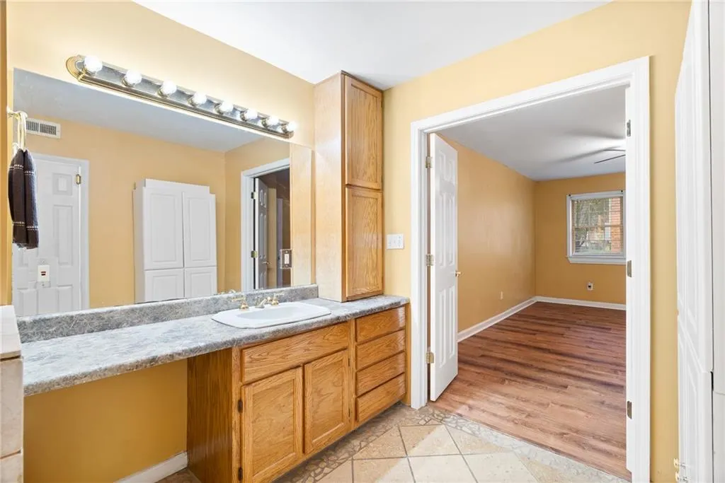 Bathroom featuring hardwood / wood-style flooring, vanity, and ceiling fan
