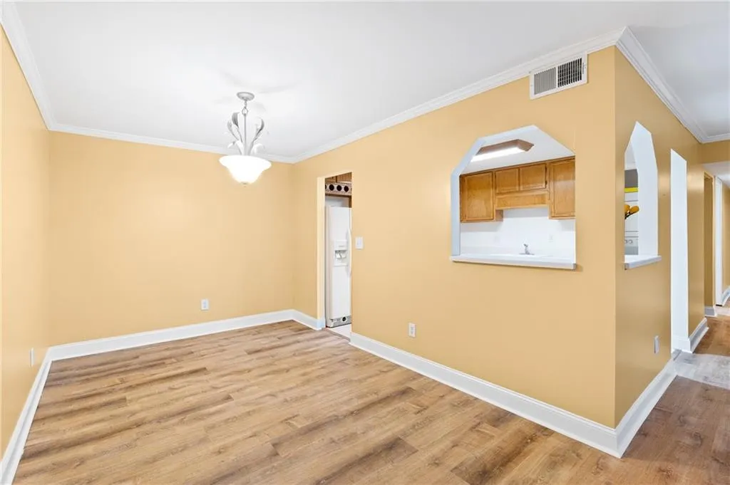 Spare room featuring light wood-type flooring and crown molding