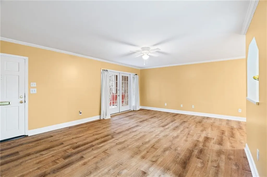 Unfurnished room featuring ceiling fan, light wood-type flooring, and crown molding