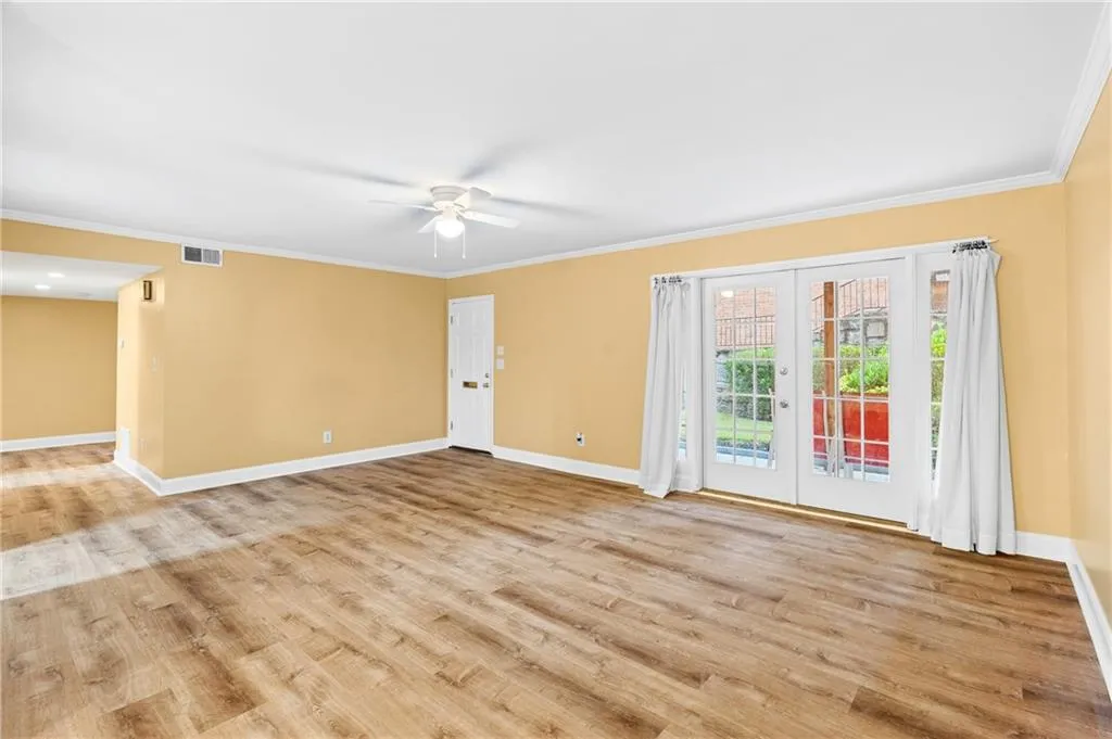 Spare room with ceiling fan, light hardwood / wood-style floors, ornamental molding, and french doors