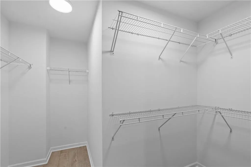 Spacious walk-in closet featuring multiple wire shelving systems with hanging rods, ample storage capacity, and recessed ceiling lighting.