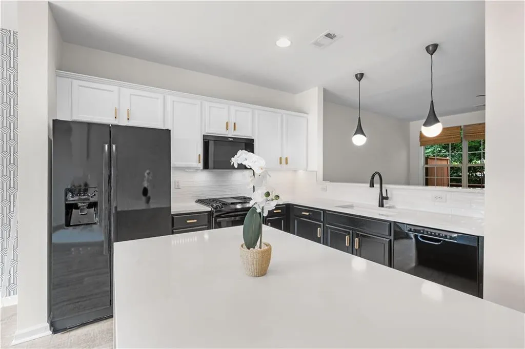 Thoughtfully designed with white quartz countertops, black and white cabinets, beautiful modern lighting and gold finish cabinet hardware.