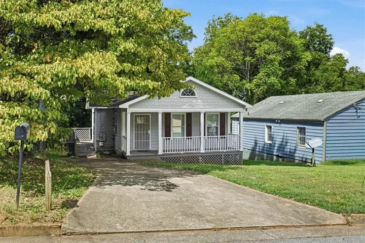 Property with a gabled roofline and a covered front porch featuring white railings