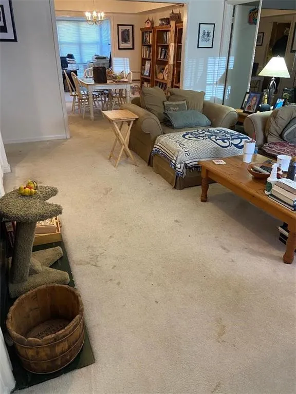 Carpeted living room with a chandelier