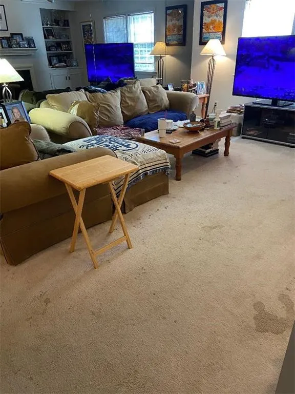 Carpeted living area featuring a fireplace