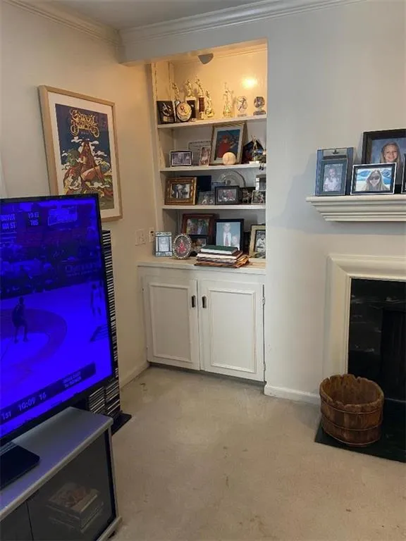 Bar with light colored carpet and crown molding