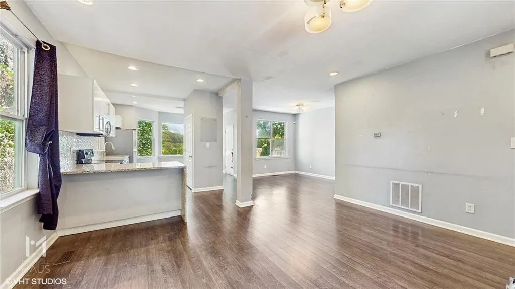 Open Concept featuring dark wood-style flooring and recessed lighting, and natural light