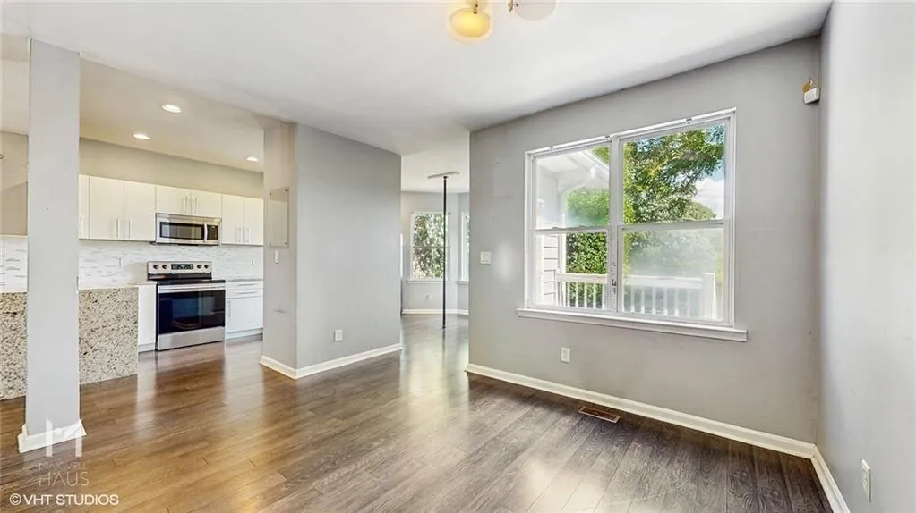 Unfurnished living room featuring dark wood-style flooring, healthy amount of natural light, and recessed lighting
