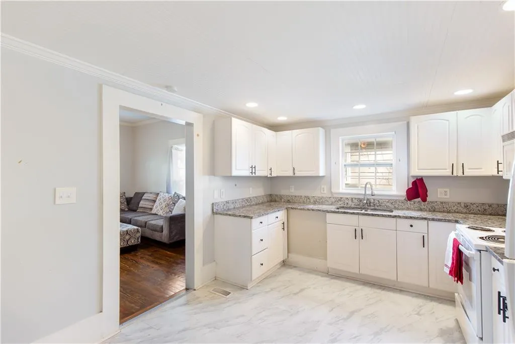 Kitchen with sink, white cabinets, white range oven, and light wood-type flooring