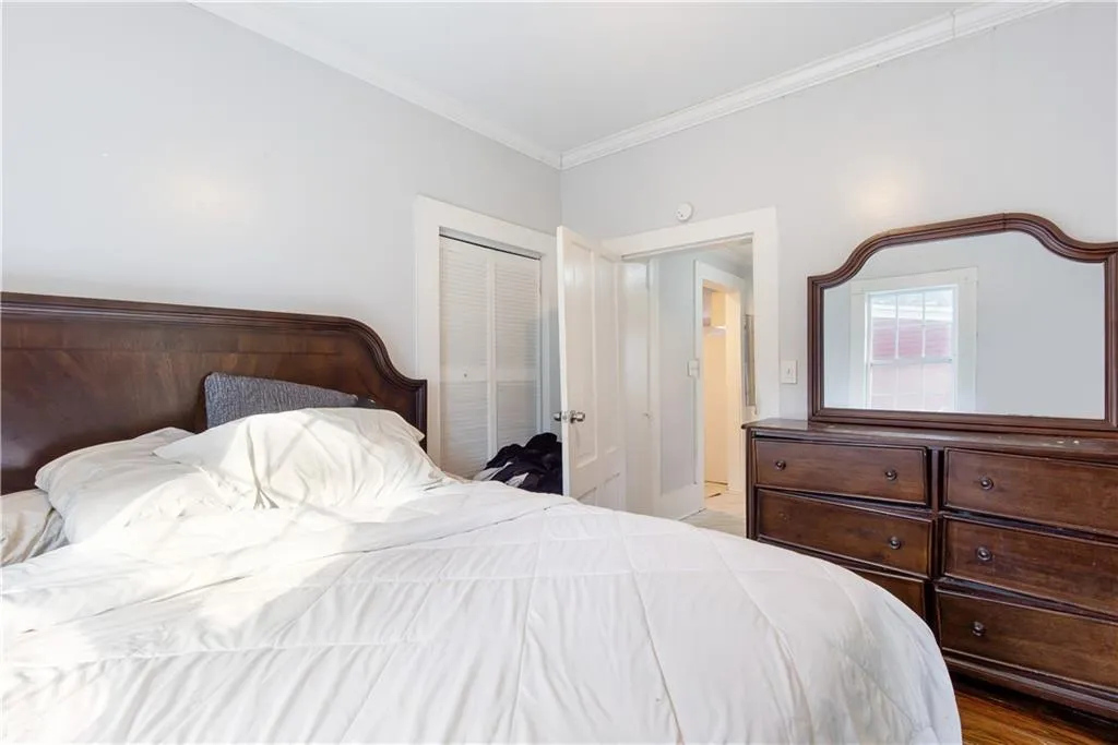 Bedroom with ornamental molding, a closet, and light hardwood / wood-style flooring