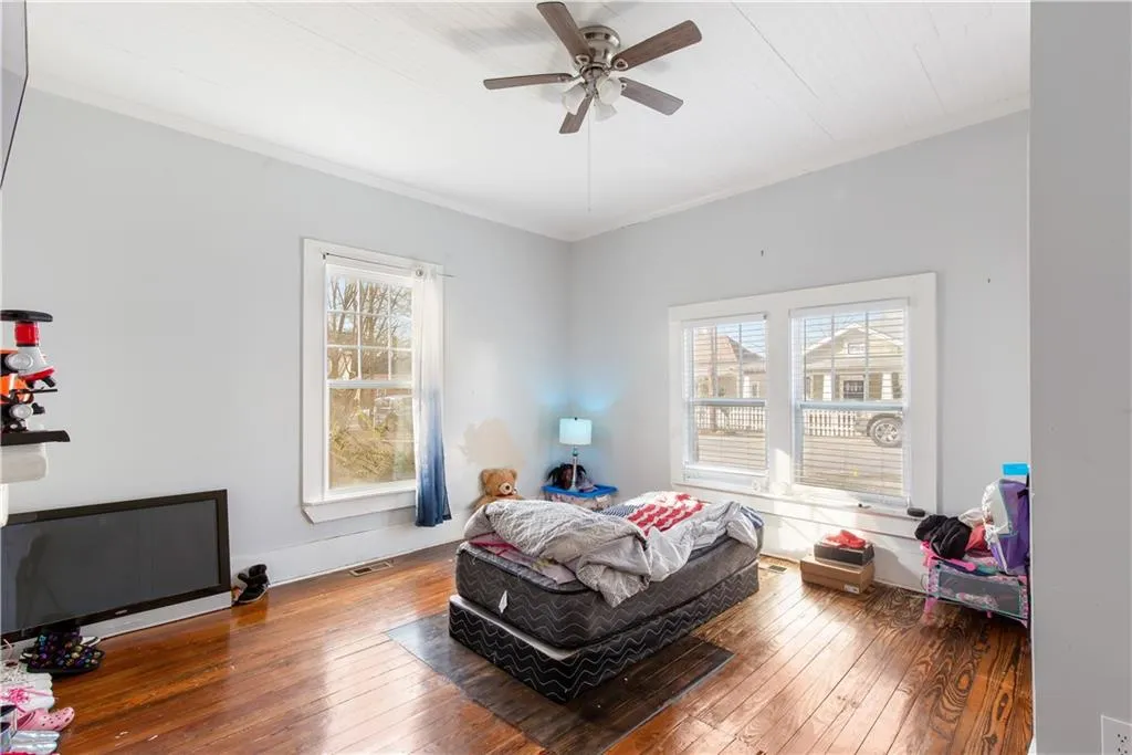Bedroom with crown molding, dark wood-type flooring, and ceiling fan